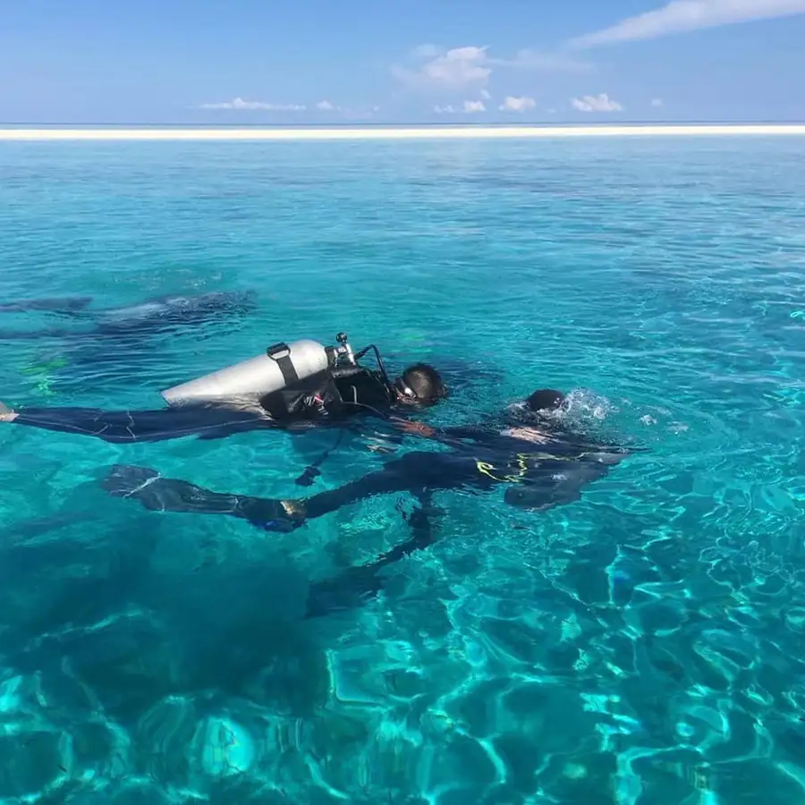 Scuba diver exploring vibrant coral reefs near Doris Mataking Resort in Semporna