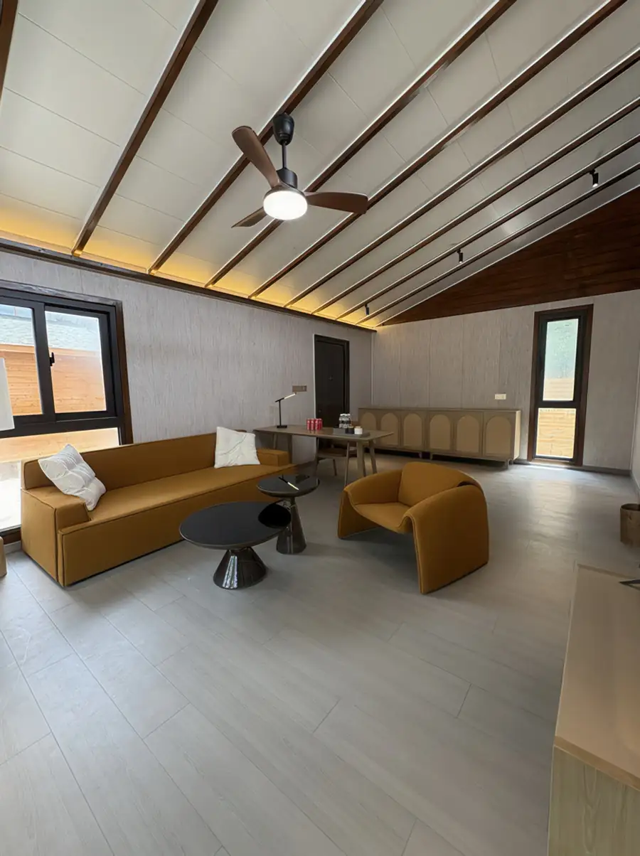 A sophisticated suite at Doris Mataking Resort featuring a modern mustard sofa, sleek coffee tables and light timber flooring