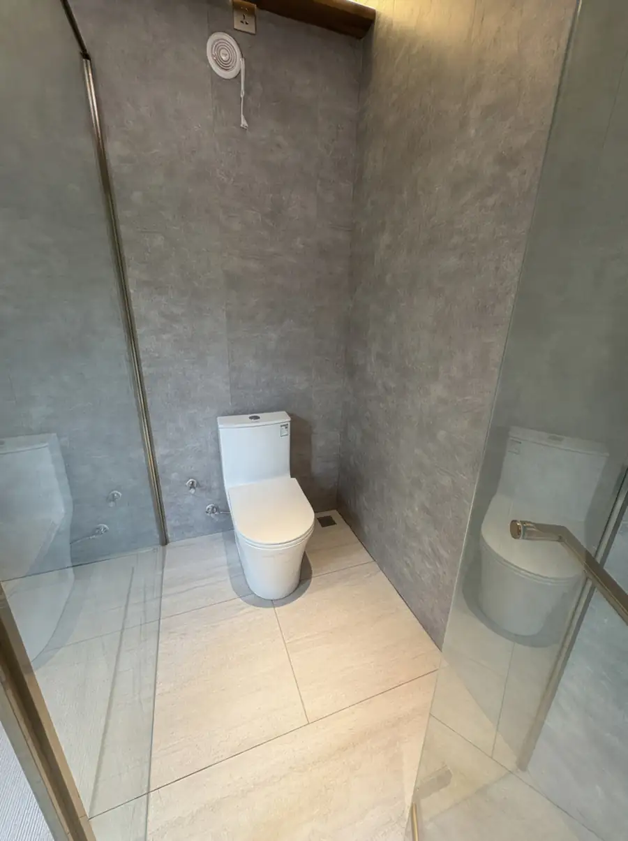 A luxurious bathroom at Doris Mataking Resort with a freestanding bathtub, marble-patterned tiles and glass shower stall