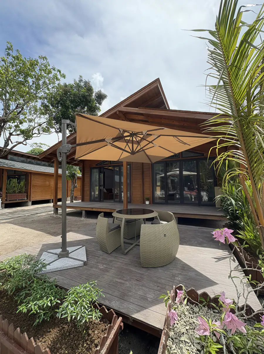 A wooden garden suite built in a local style featuring glass doors and a timber patio at Doris Mataking Resort