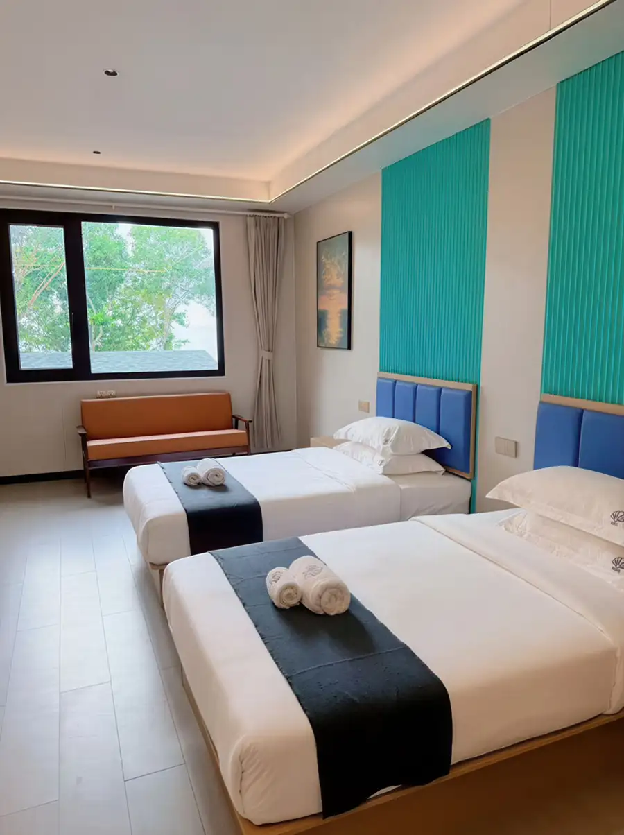 A light-filled bedroom at Doris Mataking Resort on Mataking Island with twin beds facing a scenic window and gleaming timber floors