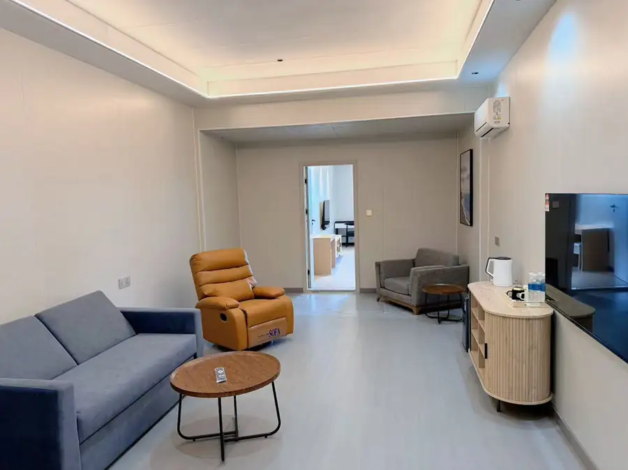 A stylish suite living area at Doris Mataking Resort with modern furniture, large TV and polished teak floors