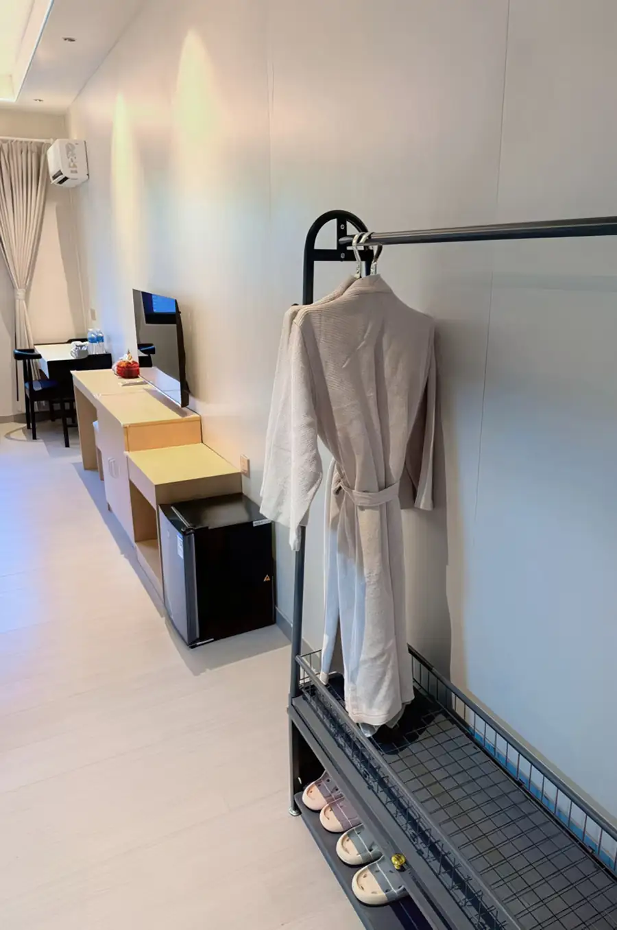 A bedroom amenity station with wooden desk, flat-screen TV and refreshment tray at Doris Mataking Resort