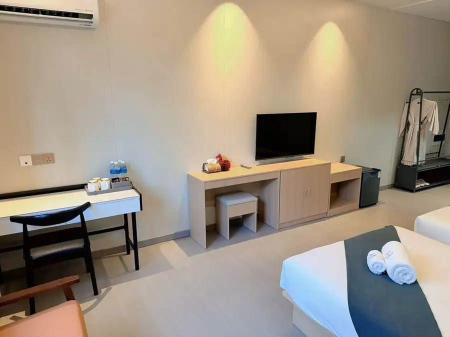 A bedroom at Doris Mataking Resort featuring a modern workspace, large TV and authentic wooden floors