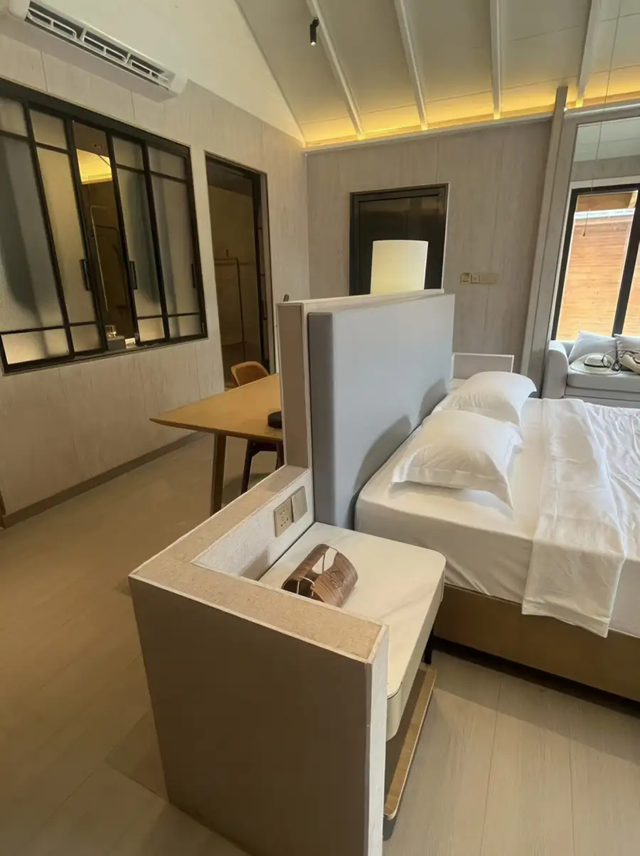 A superior bedroom at Doris Mataking Resort showcasing a large bed with modern headboard partition and polished teak wood floors