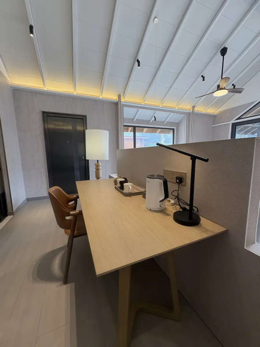 A sleek workspace at Doris Mataking Resort featuring a dedicated wooden desk with designer lighting