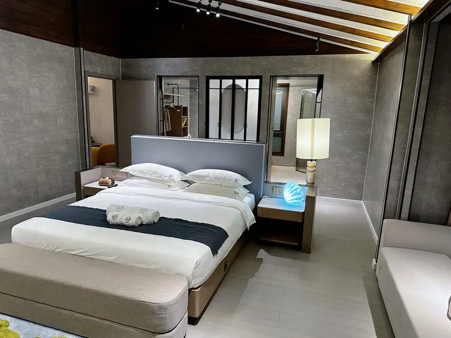 A VIP bedroom at Doris Mataking Resort featuring a large bed with a seashell-inspired lamp and glossy hardwood floors