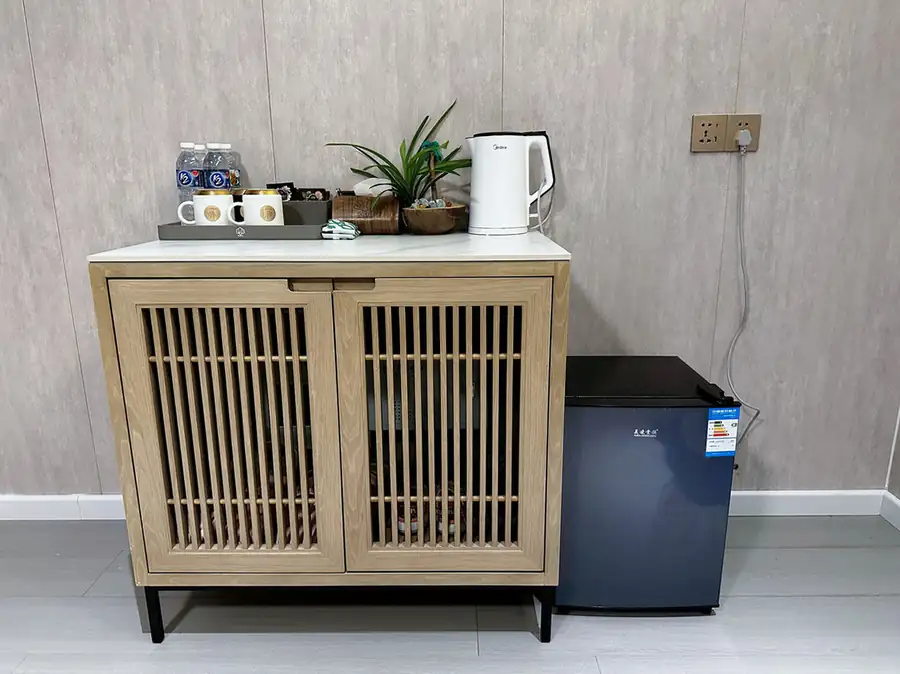 A luxury refreshment cabinet with mini fridge and tea station on polished teak floors at Doris Mataking Resort